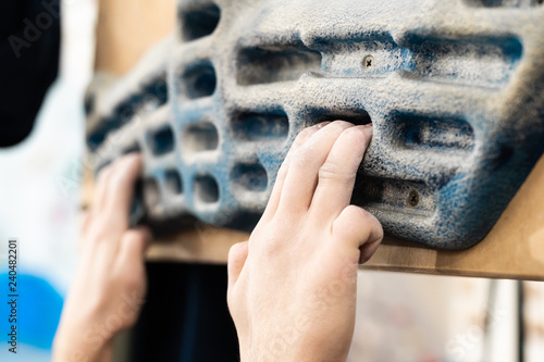 Training fingers on the fingerboard at the climbing gym photo