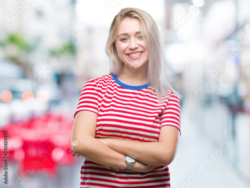 Young blonde woman over isolated background happy face smiling with crossed arms looking at the camera. Positive person.