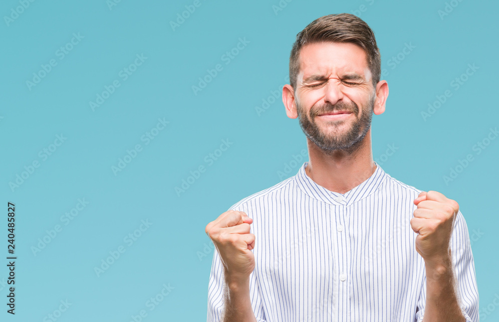 Young handsome man over isolated background very happy and excited doing winner gesture with arms raised, smiling and screaming for success. Celebration concept. Young handsome man over isolated background very happy and excited doing winner gesture with arms raised, smiling and screaming for success. Celebration concept.