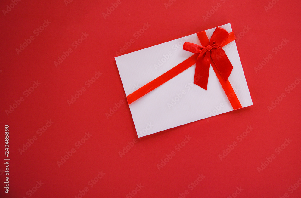 Gift card on red background with red ribbon bow Gift voucher on red background top view copy space Gift card on red background with red ribbon bow Gift voucher on red background top view copy space