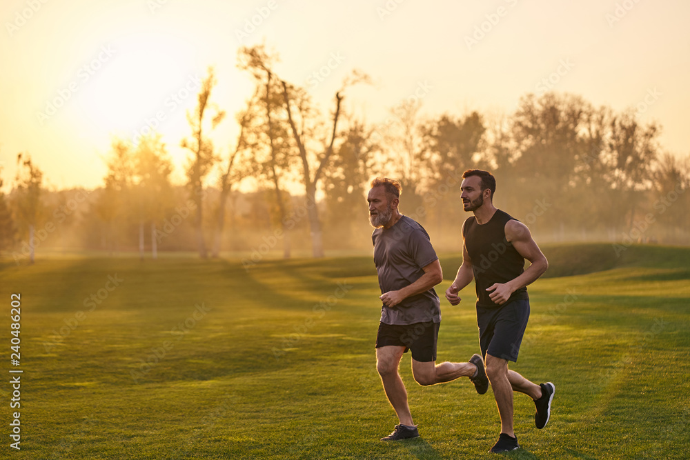 Obraz premium The happy sportsmen running in the beautiful park