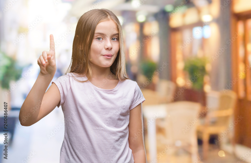 Young beautiful girl over isolated background showing and pointing up with finger number one while smiling confident and happy.
