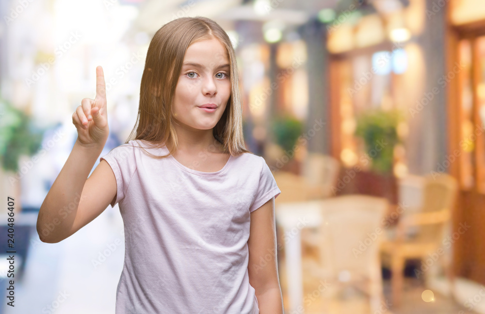 Young beautiful girl over isolated background showing and pointing up with finger number one while smiling confident and happy. Young beautiful girl over isolated background showing and pointing up with finger number one while smiling confident and happy.