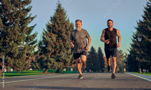 The old and young sportsmen running on the road