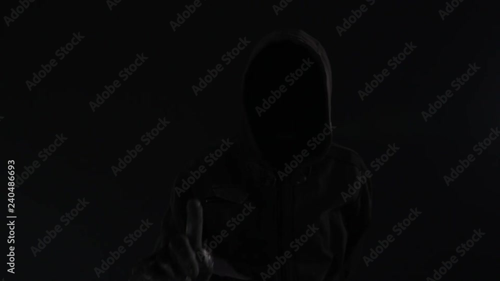 Hooded computer hacker click virtual screen, low key slow motion footage for text or graphics mock up Hooded computer hacker click virtual screen, low key slow motion footage for text or graphics mock up