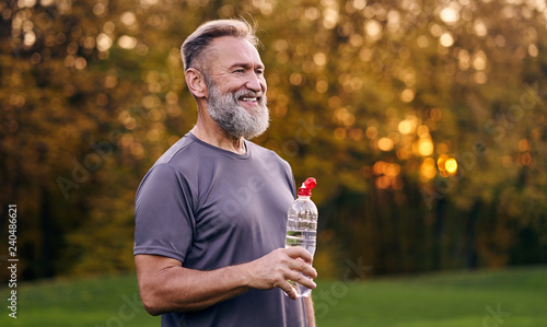 The old man holding bottle of a water