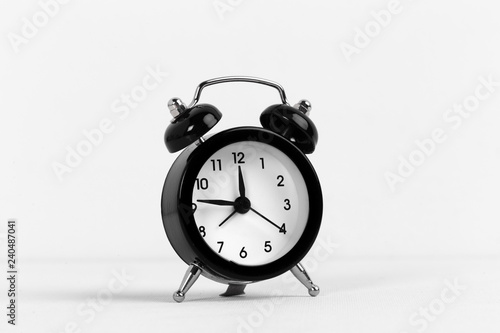 Black vintage alarm clock on a white background close up