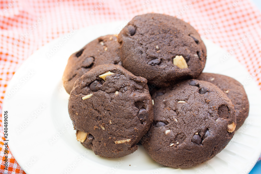 Chocolate cookies on orange fabric top view close up