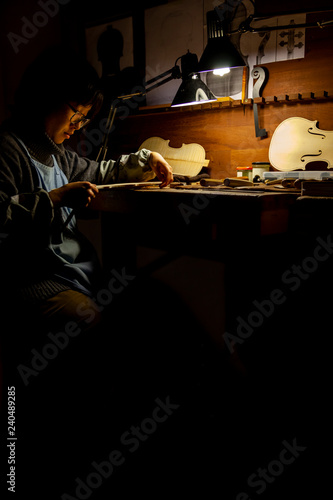 Foto female craftsman violin maker working on a new violin