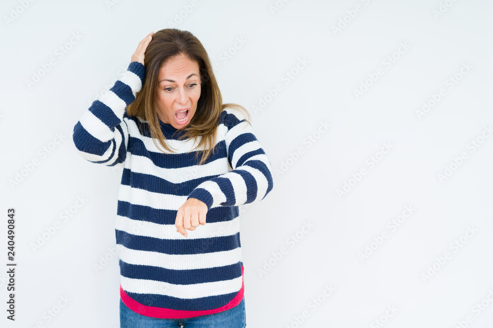Beautiful middle age woman wearing navy sweater over isolated background Looking at the watch time worried, afraid of getting late Beautiful middle age woman wearing navy sweater over isolated background Looking at the watch time worried, afraid of getting late