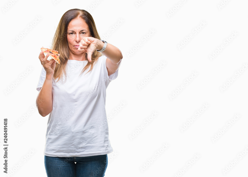 Middle age hispanic woman eating pizza slice over isolated background with angry face, negative sign showing dislike with thumbs down, rejection concept Middle age hispanic woman eating pizza slice over isolated background with angry face, negative sign showing dislike with thumbs down, rejection concept