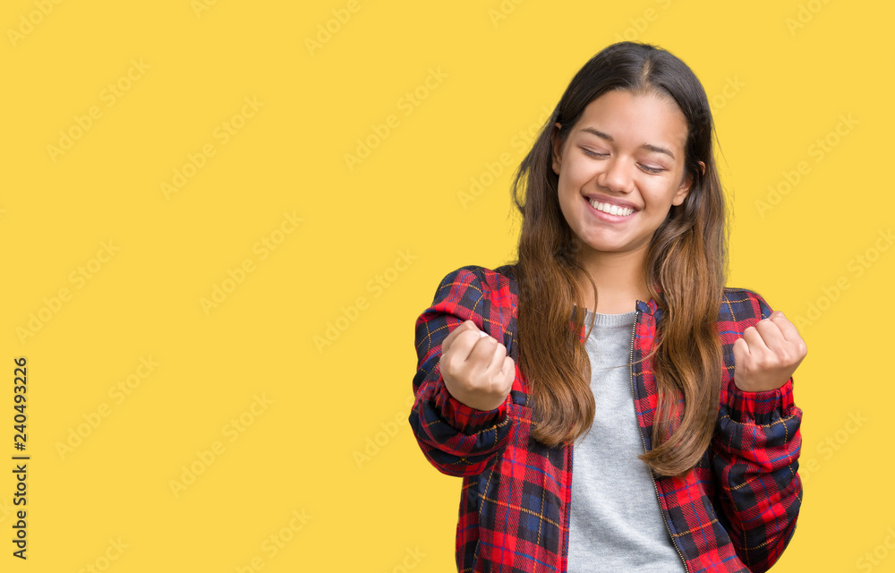 Young beautiful brunette woman wearing a jacket over isolated background very happy and excited doing winner gesture with arms raised, smiling and screaming for success. Celebration concept. Young beautiful brunette woman wearing a jacket over isolated background very happy and excited doing winner gesture with arms raised, smiling and screaming for success. Celebration concept.