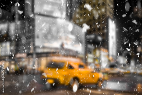 Defocused blur New York City midtown Manhattan street scene with yellow taxi cab and snowflakes falling during winter snow storm
