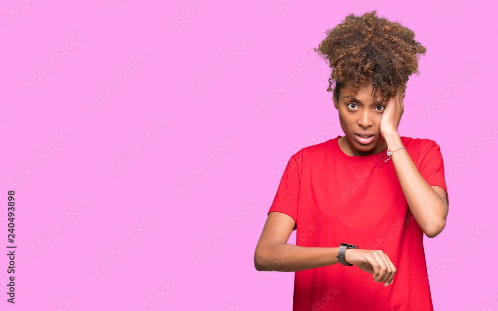 Beautiful young african american woman over isolated background Looking at the watch time worried, afraid of getting late Beautiful young african american woman over isolated background Looking at the watch time worried, afraid of getting late