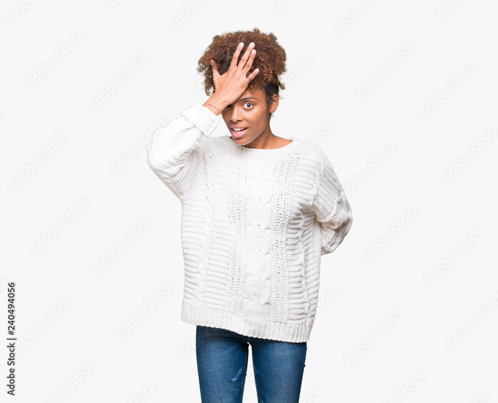 Beautiful young african american woman wearing winter sweater over isolated background surprised with hand on head for mistake, remember error. Forgot, bad memory concept. Beautiful young african american woman wearing winter sweater over isolated background surprised with hand on head for mistake, remember error. Forgot, bad memory concept.