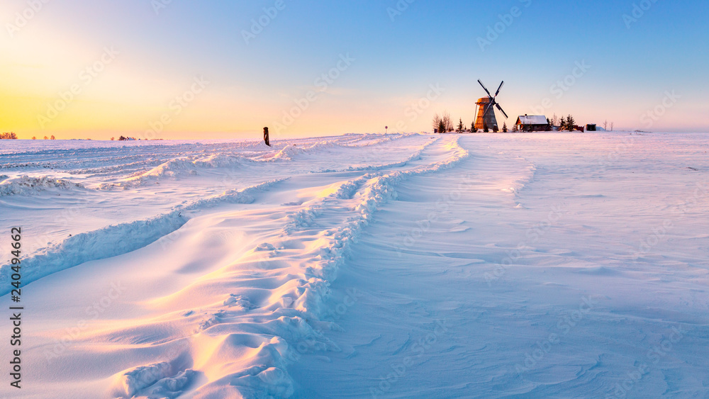 Obraz na płótnie Wooden windmill on background winter sunrise. Dudutki village, Minsk Region, Belarus w salonie