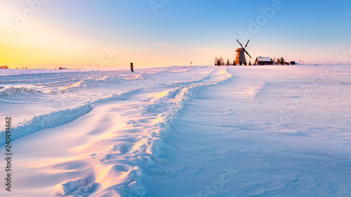Wooden windmill on background winter sunrise. Dudutki village, Minsk Region, Belarus