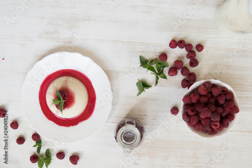 Light background. Summer dessert. Panakota with raspberries. Vertical shot. Close up top view. photo