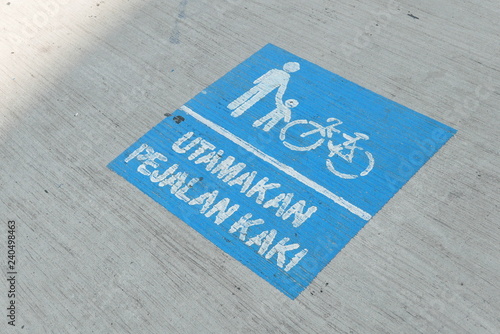 Sign of pedestrian priority or in malay language 'Utamakan Pejalan Kaki' on the street.