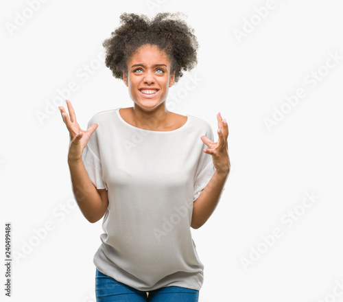 Young afro american woman over isolated background crazy and mad shouting and yelling with aggressive expression and arms raised. Frustration concept.