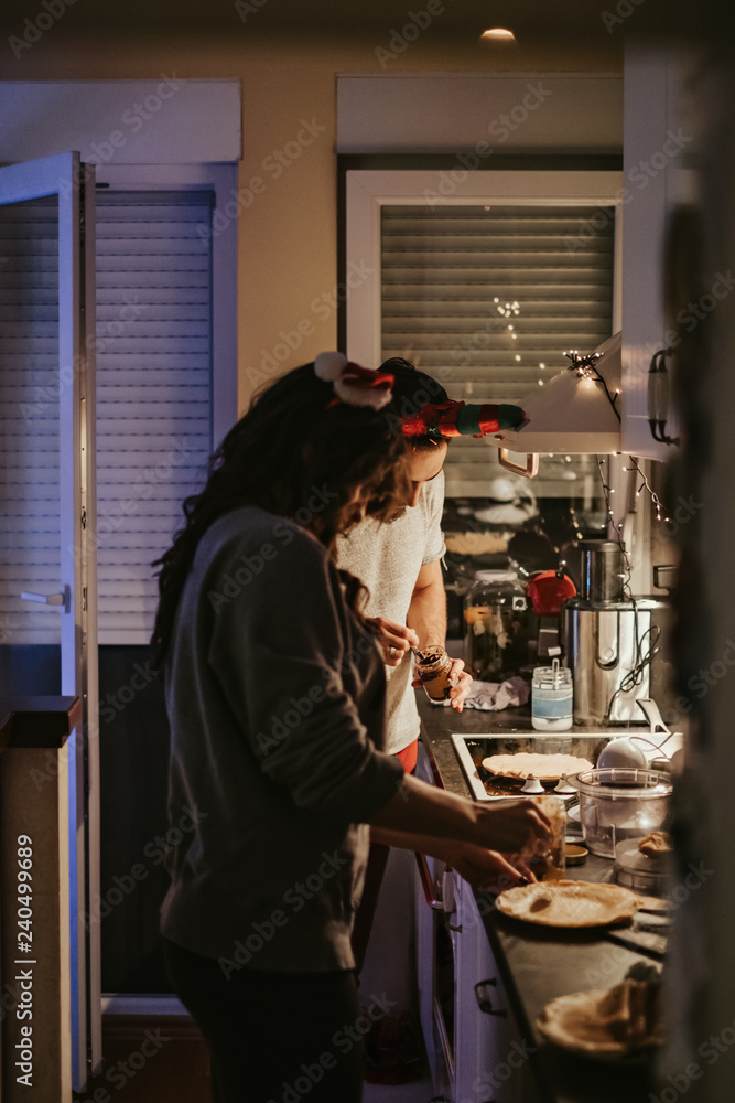 Couple preparing pancakes in the kitchen on new years eve Couple preparing pancakes in the kitchen on new years eve