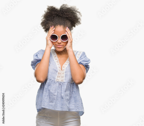 Young afro american woman wearing glasses over isolated background suffering from headache desperate and stressed because pain and migraine. Hands on head.