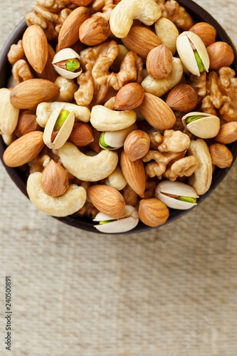 Roasted peanuts in the shell and peeled in a cup, against a gray wooden table