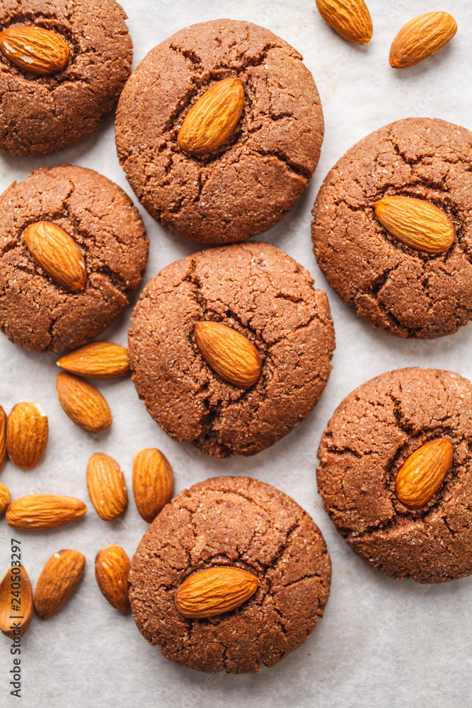 Chocolate cookies with almonds on white background, top view. Vegan dessert concept. Chocolate cookies with almonds on white background, top view. Vegan dessert concept.