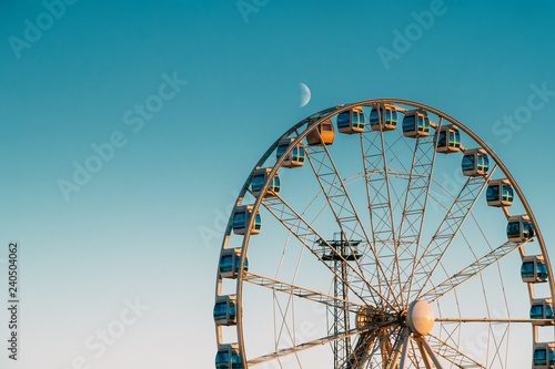 Foto Helsinki, Finland. Moon Rising Above Ferris Wheel