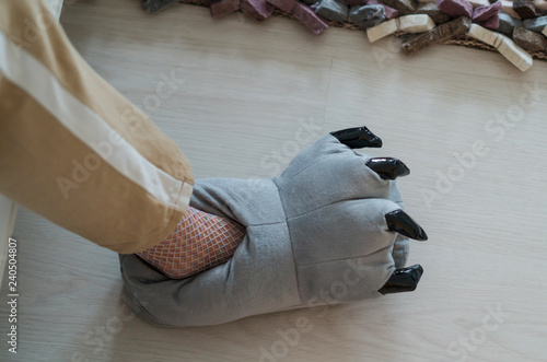Female foot wearing a funny soft toy slipper. Home shoes with claws. 