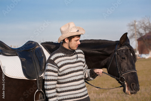  Man nearby horse, striped pullover, blue jeans, hat, close up