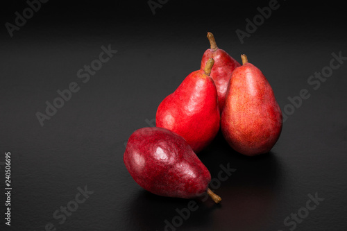 Healthy and nutritious snacks. Delicious fresh pears on a black background with text space. Starkrimson Red pears.