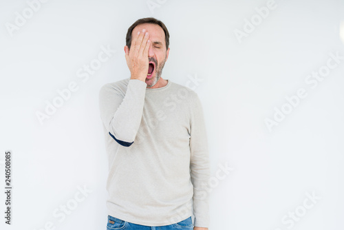 Elegant senior man over isolated background Yawning tired covering half face, eye and mouth with hand. Face hurts in pain.