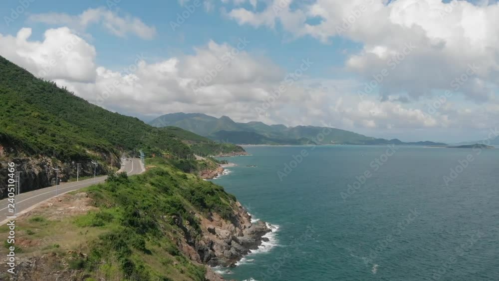 The road along the sea Vietnam Flying camera flies over the sea shore over the road with a view of the mountains of the island. Shot from a drone. The road along the sea Vietnam Flying camera flies over the sea shore over the road with a view of the mountains of the island. Shot from a drone.