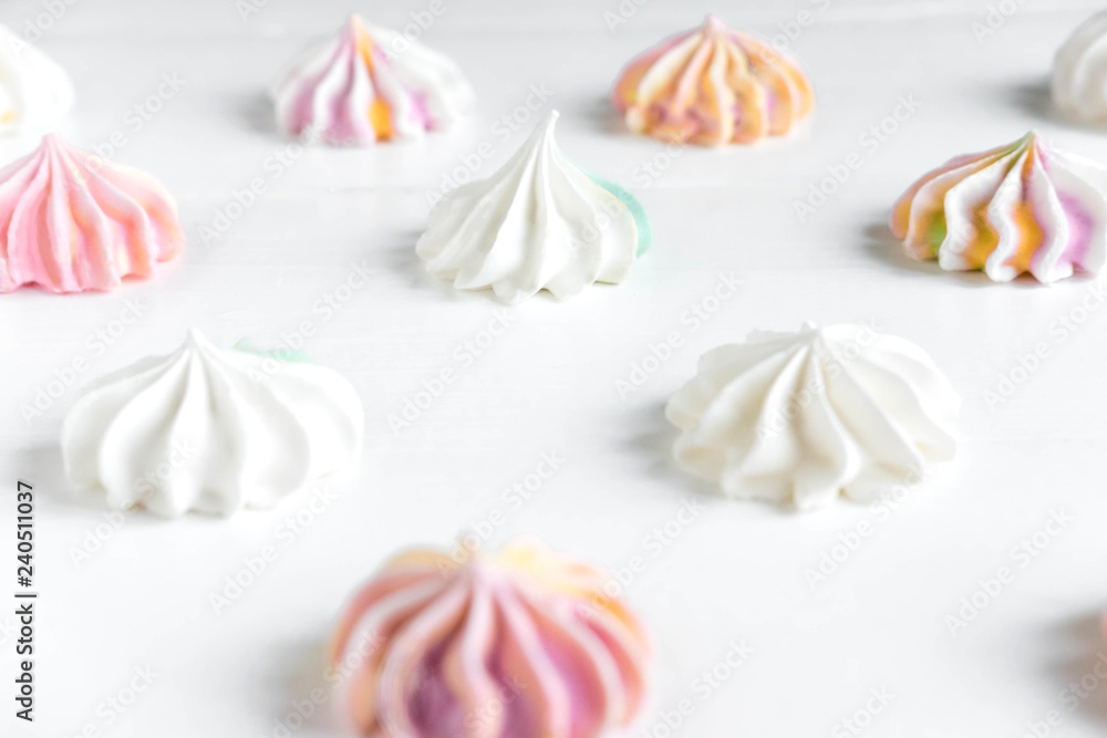 Pattern with meringues on a white wooden background. Multicolored meringues on a white background. Basis for confectionery banner, cafe, sweet shop. Meringue banner Pattern with meringues on a white wooden background. Multicolored meringues on a white background. Basis for confectionery banner, cafe, sweet shop. Meringue banner