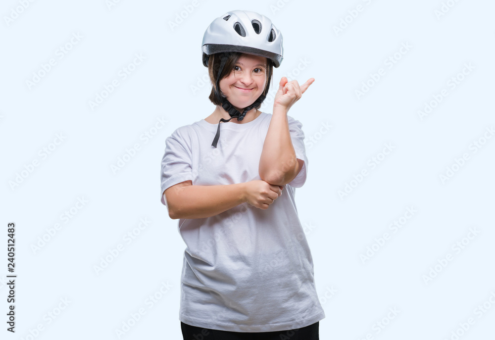 Young adult cyclist woman with down syndrome wearing safety helmet over isolated background with a big smile on face, pointing with hand and finger to the side looking at the camera. Young adult cyclist woman with down syndrome wearing safety helmet over isolated background with a big smile on face, pointing with hand and finger to the side looking at the camera.