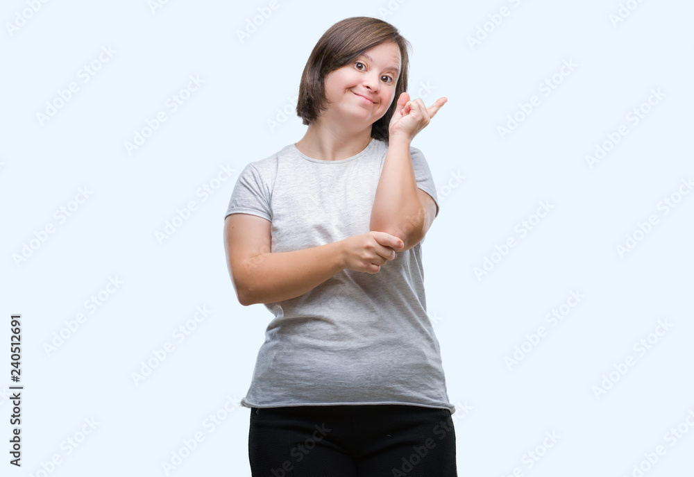 Young adult woman with down syndrome over isolated background with a big smile on face, pointing with hand and finger to the side looking at the camera.