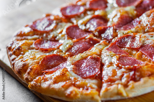 Pepperoni Pizza with Mozzarella cheese  salami  Tomatoes  pepper. Italian pizza on wooden table background