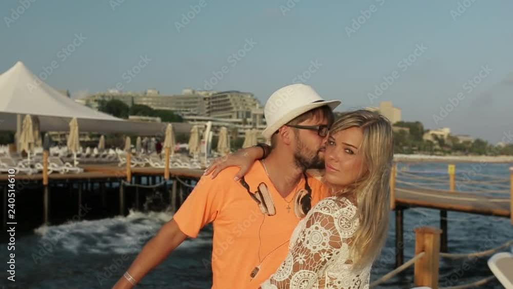 Loving couple hugging and kissing against the background of the sea Loving couple hugging and kissing against the background of the sea