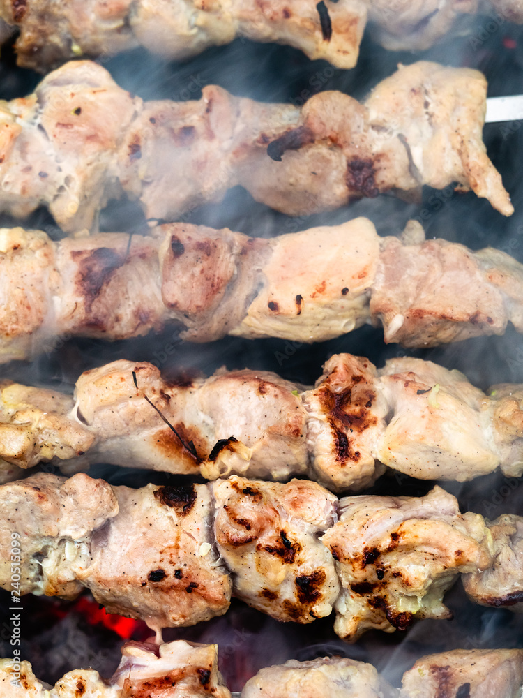 several pork kebabs are roasted over hot coals several pork kebabs are roasted over hot coals