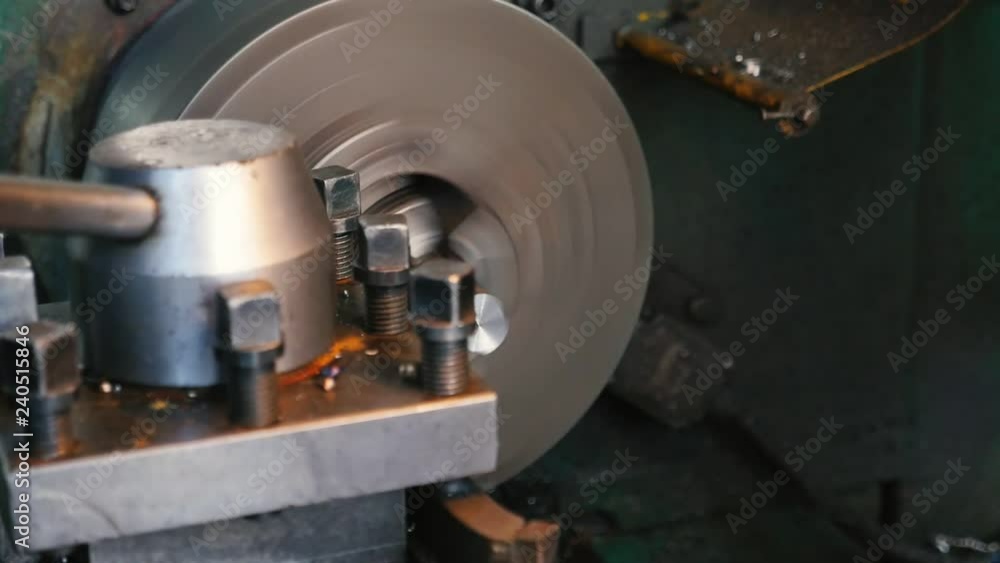 Chisel cutting chips from a metallic rod fixed to a lathe cylinder on workshop Chisel cutting chips from a metallic rod fixed to a lathe cylinder on workshop
