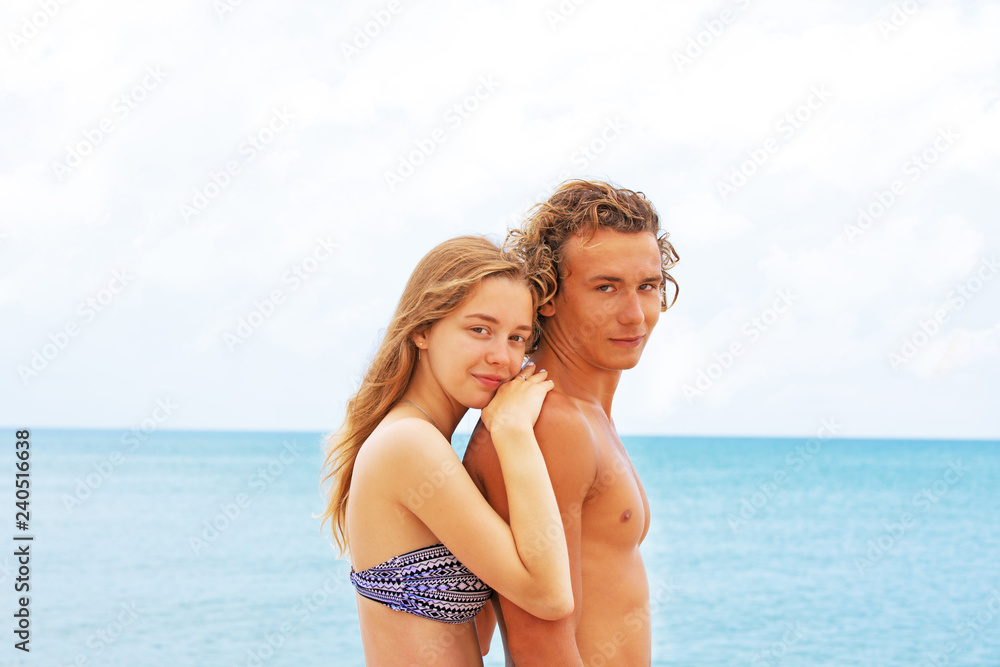 Portrait of young couple in love at beach and enjoying time being together. Young couple having fun on a sandy coast.