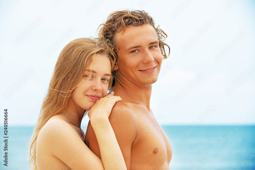 Portrait of young couple in love at beach and enjoying time being together. Young couple having fun on a sandy coast. Portrait of young couple in love at beach and enjoying time being together. Young couple having fun on a sandy coast.