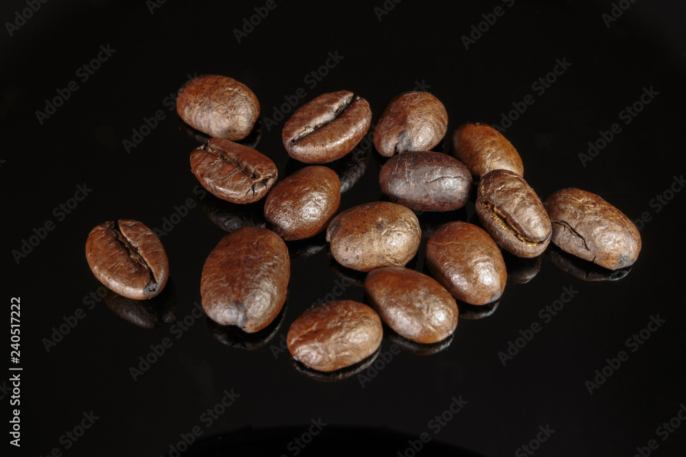 Fototapeta premium Well roasted coffee beans on a black background closeup.