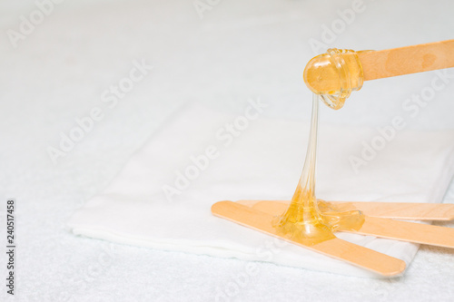 sugar paste or wax honey for hair removing with wooden waxing spatula sticks - depilation and beauty concept
