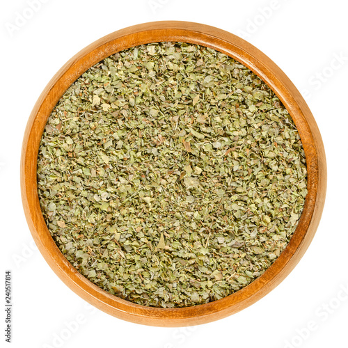 Dried marjoram in wooden bowl. Origanum majorana, also sweet, knotted or pot marjoram. Green herb and spice with sweet pine and citrus flavors. Macro food photo closeup from above on white background.