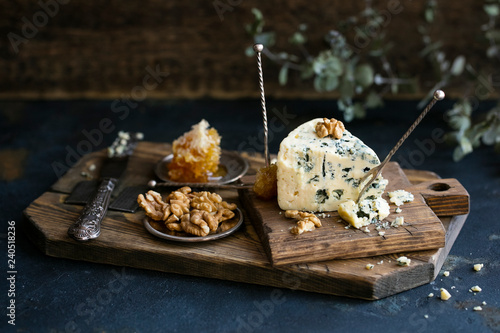 Tablou pe pânză Danish blue cheese on a wooden board with walnut kernels