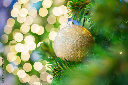 Glittering Baubles with Glowing Sparkling Gold defocused Light (bokeh) Illumination background with decorated Christmas Tree. Special Holidays, Festival design decoration, New Year Celebration, Party.