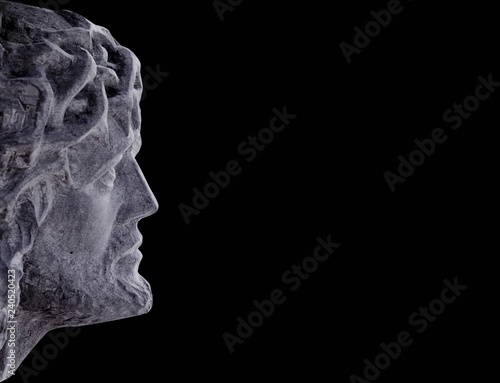 An ancient statue of Jesus Christ in profile. Religion, faith, suffering, God concept.