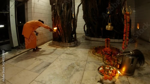 Hindu ceremony by monk Shiv a temple inside atributes decorated by flowers big banyan trees light photo